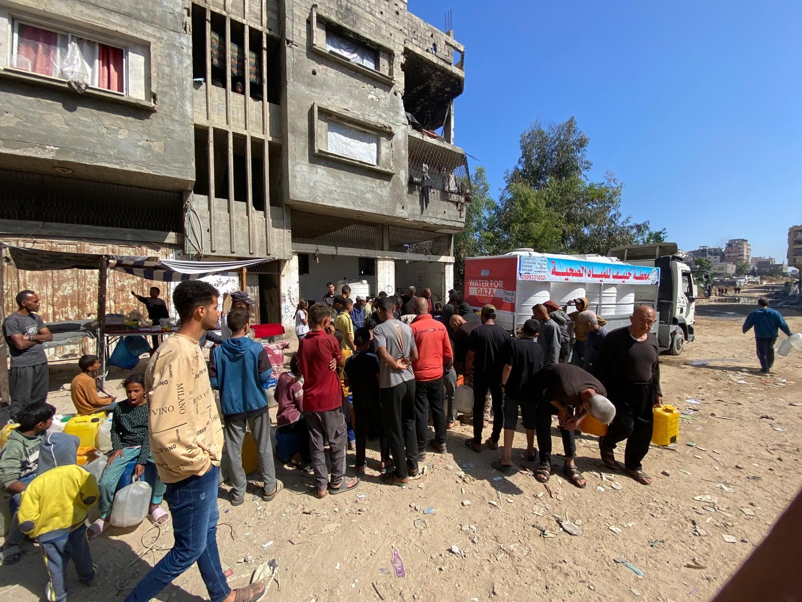 Children in Gaza holding a Muntada Aid sign