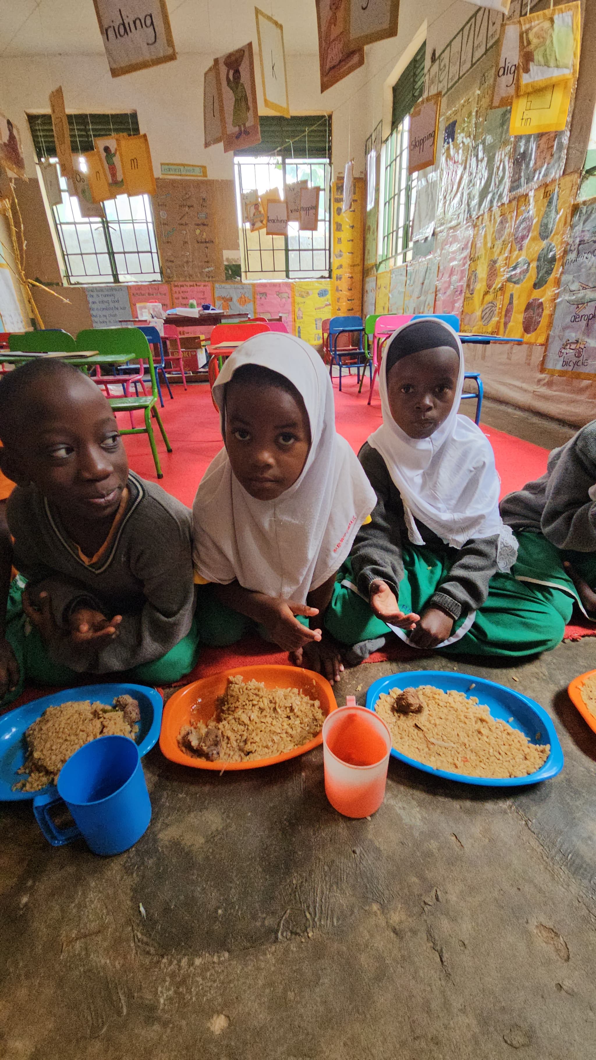 Children eating a school meal provided by Muntada Aid