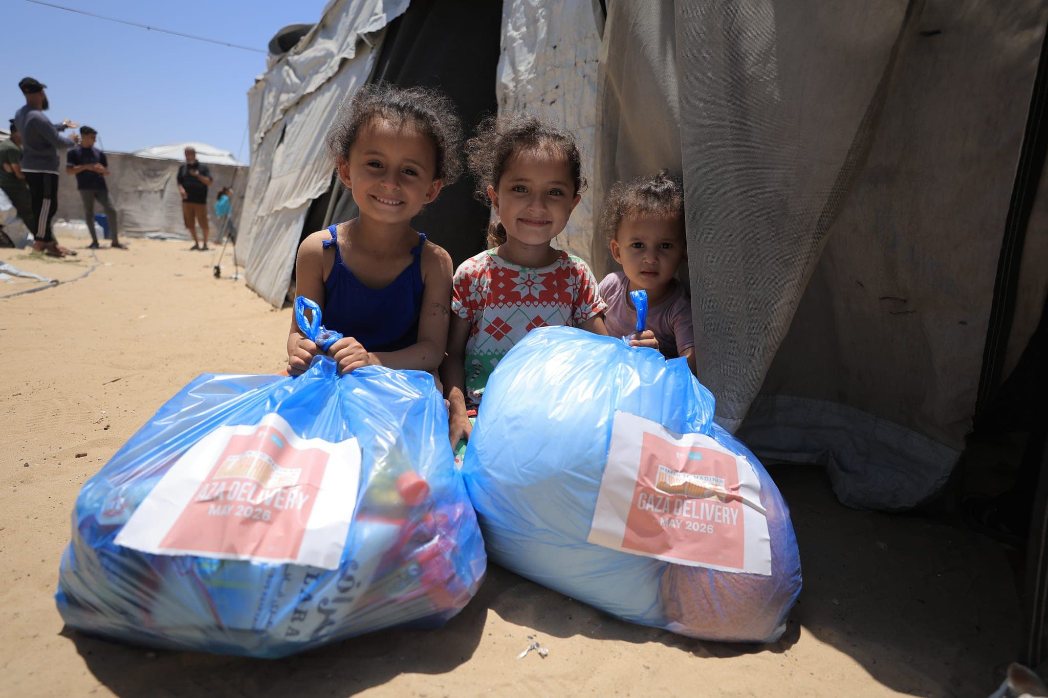 Children in Gaza with Muntada Aid family food packs